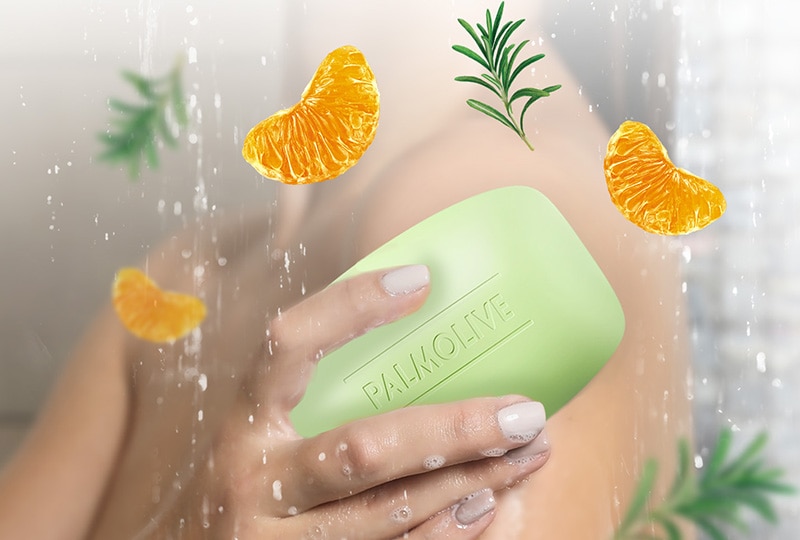 Mujer usando el Jabón Palmolive Naturals Mandarina y Romero